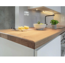 Cuisine moderne avec un plan de travail en bois massif, des meubles et un robinet. Espace de travail lumineux et organisé.