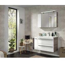 Salle de bain moderne avec meuble sous-vasque blanc et bois, lavabo et armoire de toilette à trois portes avec éclairage LED.