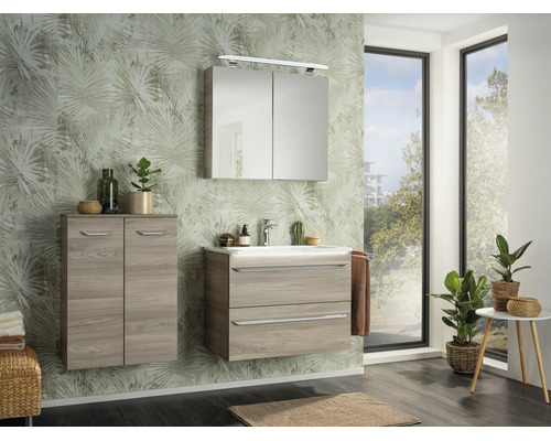 Salle de bains moderne avec meuble sous-lavabo aspect bois clair, lavabo blanc, armoire de toilette avec éclairage et meuble d'appoint assorti.
