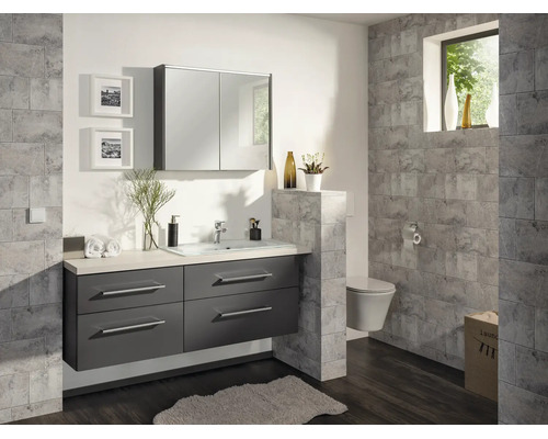 Modernes Badezimmer mit dunkelgrauem Waschtischunterschrank, integriertem Waschbecken, Spiegelschrank und grauen Wandfliesen in Steinoptik.
