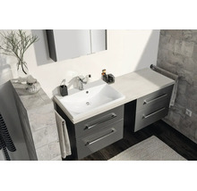 Salle de bains moderne avec meuble sous-lavabo gris, lavabo blanc et armoire de toilette sur fond de carrelage gris.