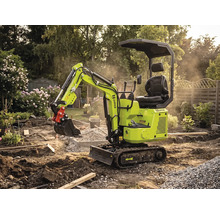 Zipper Minibagger auf Raupenketten bei Gartenarbeiten in einer Baustelle mit Erde, Kies und Pflanzen im Hintergrund.