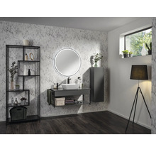 Salle de bains moderne avec papier peint aspect marbre, meuble gris foncé avec vasque à poser, miroir rond lumineux et étagère noire.