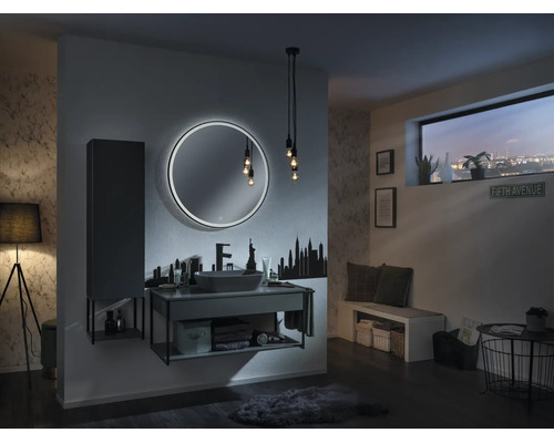 Salle de bain moderne avec miroir LED rond, meuble sous-lavabo gris, vasque à poser et sticker mural skyline.