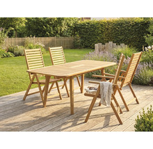 Salon de jardin en bois avec table rectangulaire et quatre chaises pliantes sur une terrasse en bois dans un jardin.
