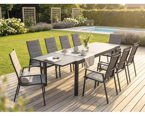 Salle à manger de jardin moderne sur une terrasse en bois avec une grande table en métal et des chaises à haut dossier en textile.