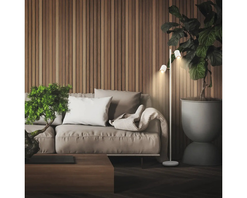 Scène de salon moderne avec un lampadaire à deux spots à côté d'un canapé devant un mur en lattes de bois et une grande plante d'intérieur.