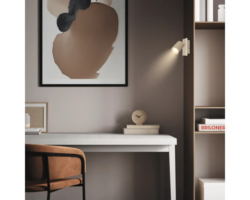 Applique murale moderne comme lampe de lecture sur une étagère au-dessus d'un bureau, style minimaliste avec art abstrait.