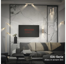 Salon moderne avec luminaires Briloner série IDA: lampadaire, plafonnier, suspension et appliques murales devant un mur aspect marbre.