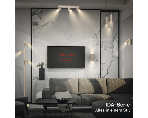 Salon moderne avec luminaires de la série IDA, canapé gris, mur aspect marbre et logo Briloner sur le téléviseur.