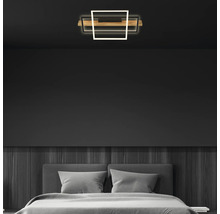 Plafonnier LED moderne dans une chambre à coucher minimaliste avec des murs sombres, des panneaux en bois et un lit gris.