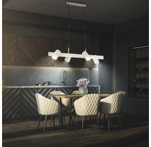 Suspension moderne à quatre lampes au-dessus d'une table en bois avec des chaises matelassées dans une cuisine contemporaine sombre.