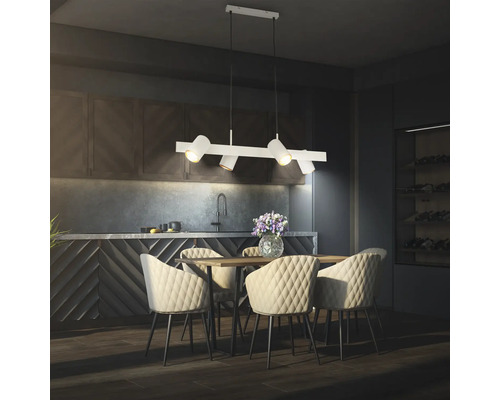 Suspension moderne à quatre lampes au-dessus d'une table en bois avec des chaises matelassées dans une cuisine contemporaine sombre.