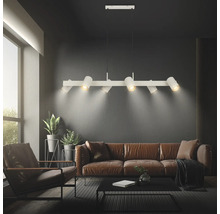 Suspension moderne en métal avec six spots orientables au-dessus d'un canapé dans un salon.