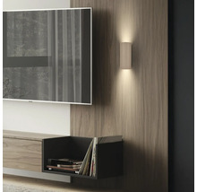 Applique murale cylindrique nervurée moderne sur panneau de bois dans un salon, éclairage vers le haut et vers le bas à côté d'un téléviseur.
