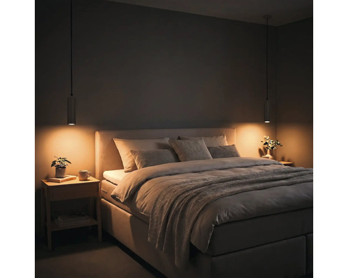 Chambre à coucher moderne avec lit double rembourré, deux suspensions et tables de chevet en bois sous un éclairage chaud.