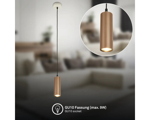 Suspension moderne avec abat-jour métallique cylindrique strié et douille GU10 pour maximum 9 Watts dans un salon lumineux et organisé.
