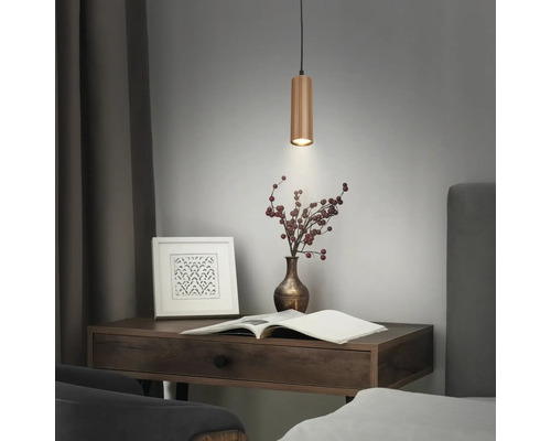 Suspension cylindrique en bois au-dessus d'un bureau avec un livre et un vase.