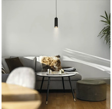 Suspension LED cylindrique moderne au-dessus d une table basse dans un salon lumineux et organisé avec canapé et pouf.