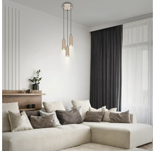 Salon moderne avec suspension à 3 lampes, abat-jours cylindriques et canapé d'angle avec coussins décoratifs.