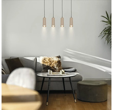 Quatre suspensions cylindriques en bois dans un salon moderne avec un canapé gris, une table basse et un pouf.