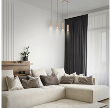 Suspension à 4 lampes avec abat-jour cylindriques en bois dans un salon moderne et lumineux au-dessus d'un grand canapé d'angle.
