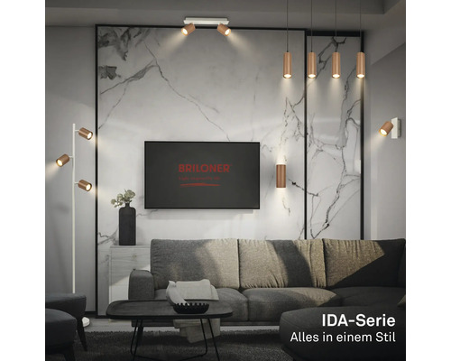 Salon moderne avec lampes en métal de la série IDA de Briloner, canapé gris et mur aspect marbre. Briloner Logo sur le téléviseur.