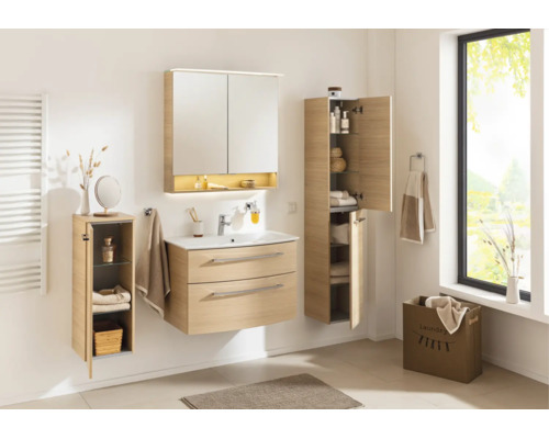 Ensemble de meubles de salle de bains clair aspect bois avec meuble sous vasque, armoire de toilette et deux colonnes dans une salle de bains.