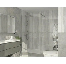 Douche à l'italienne moderne avec paroi en verre, système de douche chromé, receveur de douche plat et carrelage dans une salle de bain lumineuse.