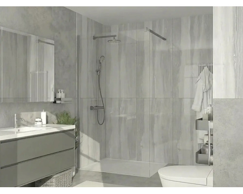 Douche à l'italienne moderne avec paroi en verre, système de douche chromé, receveur de douche plat et carrelage dans une salle de bain lumineuse.