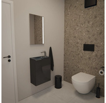 Moderne Gäste-Toilette mit wandhängender Toilette, Hängewaschbecken, Spiegel und Badaccessoires vor einer Wand in Steinoptik.