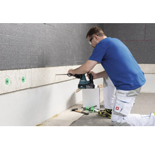 Une personne utilise un perforateur sans fil Makita pour percer un panneau d isolation murale.