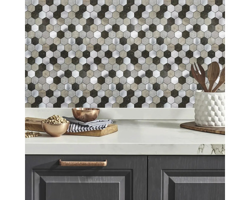 Küchenrückwand mit Hexagon-Mosaikfliesen in Metall- und Steinoptik über einer hellen Arbeitsplatte in einer modernen Küche.