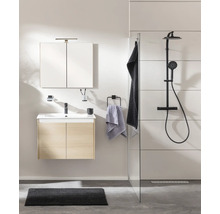 Modernes Badezimmer mit Waschtischunterschrank in Eichenoptik, Spiegelschrank und schwarzer Duscharmatur hinter einer Glastrennwand.