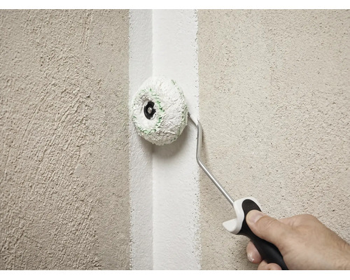 Rouleau d'angle utilisé pour peindre un angle intérieur sur un mur texturé.