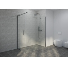 Cabine de douche moderne en verre avec robinetterie chromée, carrelage mural gris clair et carrelage de sol gris foncé dans une salle de bain claire.