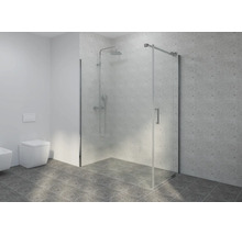 Douche à l'italienne en verre avec robinetterie chromée dans une salle de bains carrelée moderne à côté d'une toilette suspendue.
