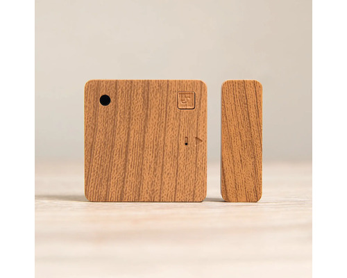 Smarter Tür- und Fenstersensor in Holzoptik, bestehend aus einem quadratischen Hauptmodul und einem schmalen Magnetkontakt.
