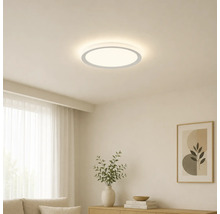 Plafonnier LED rond et plat dans un salon minimaliste et lumineux avec des meubles en bois et de la décoration.