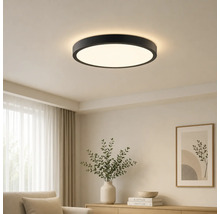 Plafonnier LED rond moderne avec cadre noir dans un salon lumineux.
