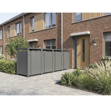 Quatre abris pour poubelles modernes en métal devant une maison en briques avec une allée pavée et des plantes.