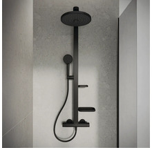 Modernes schwarzes Duschsystem mit runder Regendusche, Handbrause, zwei Ablagen und Thermostatarmatur an einer grauen Wand in Steinoptik.