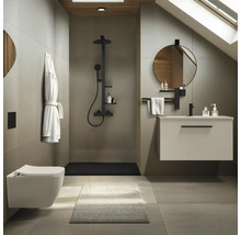 Modernes Badezimmer mit Wand-WC, begehbarer Dusche mit schwarzen Armaturen, Waschtischunterschrank und rundem Spiegel in minimalistischem Design.