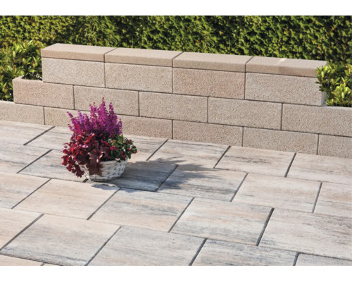 Terrasse lumineuse avec des dalles de sol rectangulaires texturées et un muret de jardin en blocs de béton.