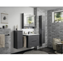 Ensemble de meubles de salle de bain gris moderne avec sous-vasque, armoire de toilette et deux colonnes sur un mur effet pierre.