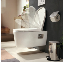 WC suspendu avec abattant à fermeture ralentie dans une salle de bains moderne avec poubelle à pédale et porte-papier toilette.