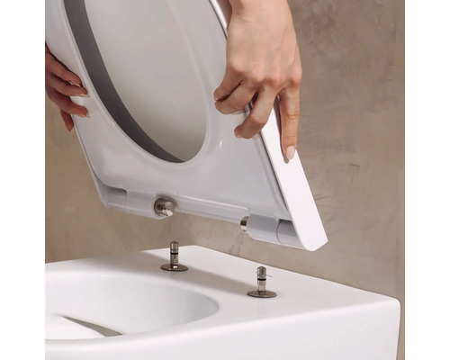 Abattant de WC avec fonction Take-Off posé sur les boulons de fixation d'un WC.