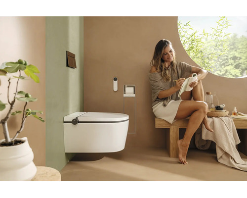 WC douche suspendu dans une salle de bains moderne et lumineuse avec une femme assise sur un banc en bois.