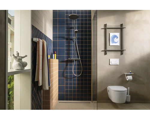 Salle de bains moderne avec carrelage carré bleu dans la douche, toilettes suspendues, colonne de douche et porte-serviettes.