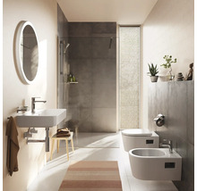 Salle de bains moderne avec lavabo mural, miroir ovale, douche à l'italienne aux carreaux gris, toilettes suspendues et bidet. Design lumineux.